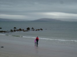 Father and daughter standing together on the shore, Co. Galway
